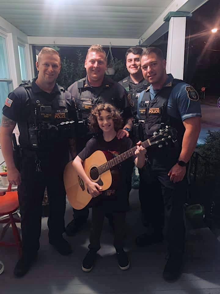 (Back, L–R) Officers Andrew Skae, Lt. Benjamin Veenema, Kevin Foley, and Marc Lecourieux with Evan. (Courtesy of <a href="https://www.facebook.com/hawthorne.pd.9">Hawthorne Police Department</a>)