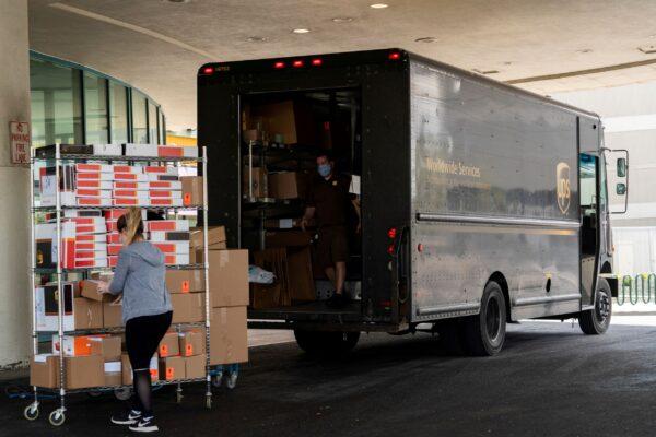 Employees of Pottery Barn load packages containing online orders onto a UPS truck in Syracuse, N.Y., on May 15, 2020. (Zachary Krahmer/Reuters)