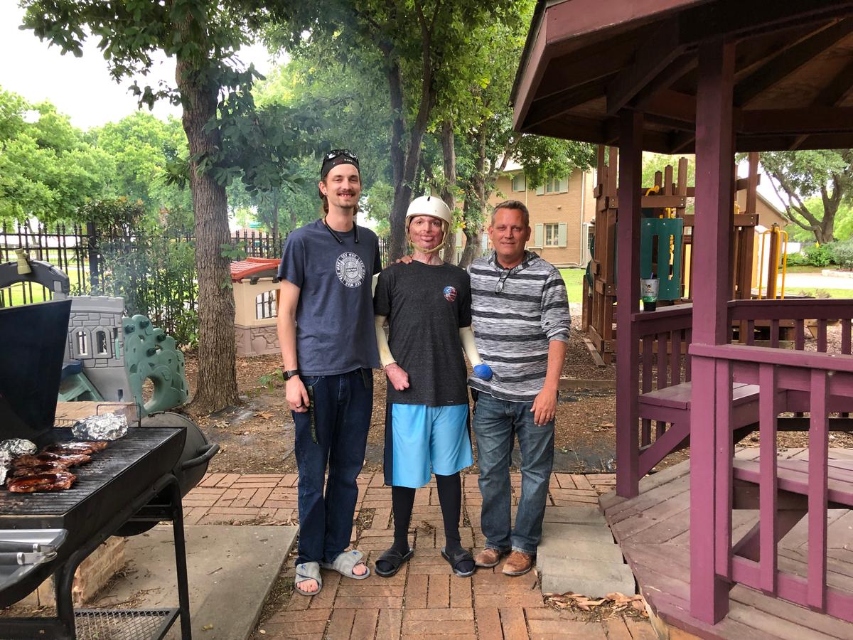 Zach with his brother, Danny (L), and father, Kar Sutterfield, while barbecuing at Brooke Army Medical Center Fisher House 1, San Antonio, Texas. (Courtesy of <a href="https://www.instagram.com/zacharyrecovery/">Deona Jo Sutterfield</a>)
