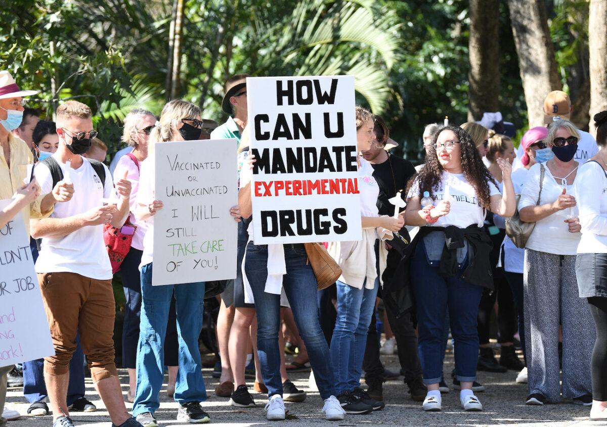 Protesters hold up signs as they march across Victoria Bridge during a rally against a mandatory Covid-19 vaccine in Brisbane, Australia, on Oct. 1, 2021. (Dan Peled/Getty Images)