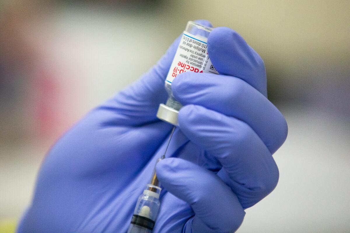 A medical volunteer prepares the Moderna COVID-19 vaccine for a patient at Lestonnac Free Clinic in Orange, Calif., on March 9, 2021. (John Fredricks/The Epoch Times)
