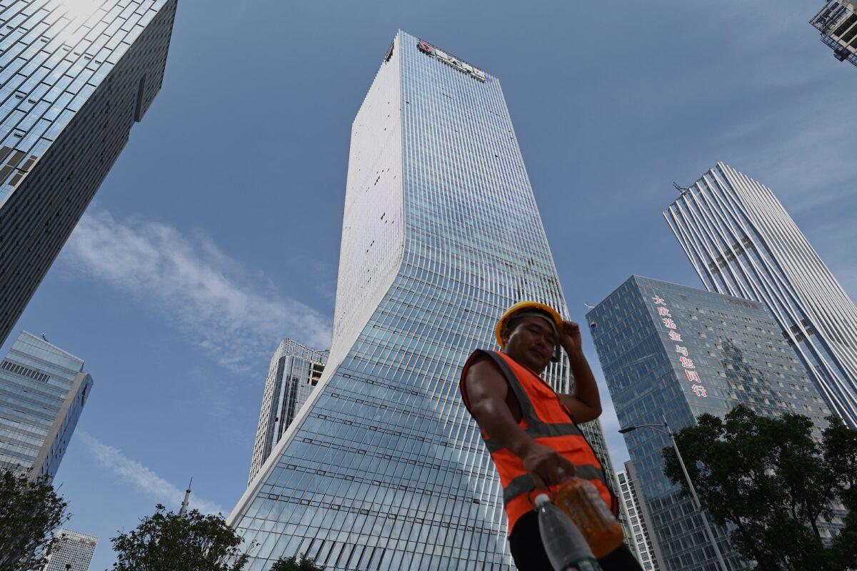 A worker walks in front of the Evergrande headquarters in Shenzhen, China, on Sept. 26, 2021. (Noel Celis/AFP via Getty Images)