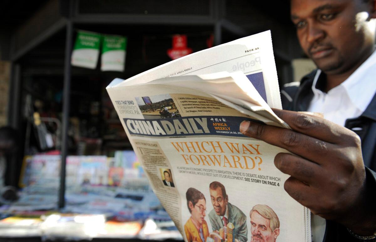 A newspaper consumer reads a copy of China's Africa edition of its daily newspaper in front of a newsstand in Nairobi, Kenyan, on Dec. 14, 2012. (Tony Karumba/AFP via Getty Images)