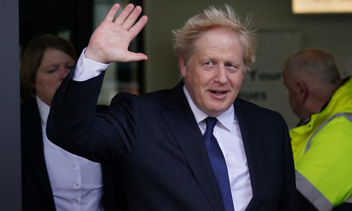 Prime Minister Boris Johnson waves as he leaves Media City in Salford, Greater Manchester, England, on Oct. 3, 2021. (Jacob King/PA)