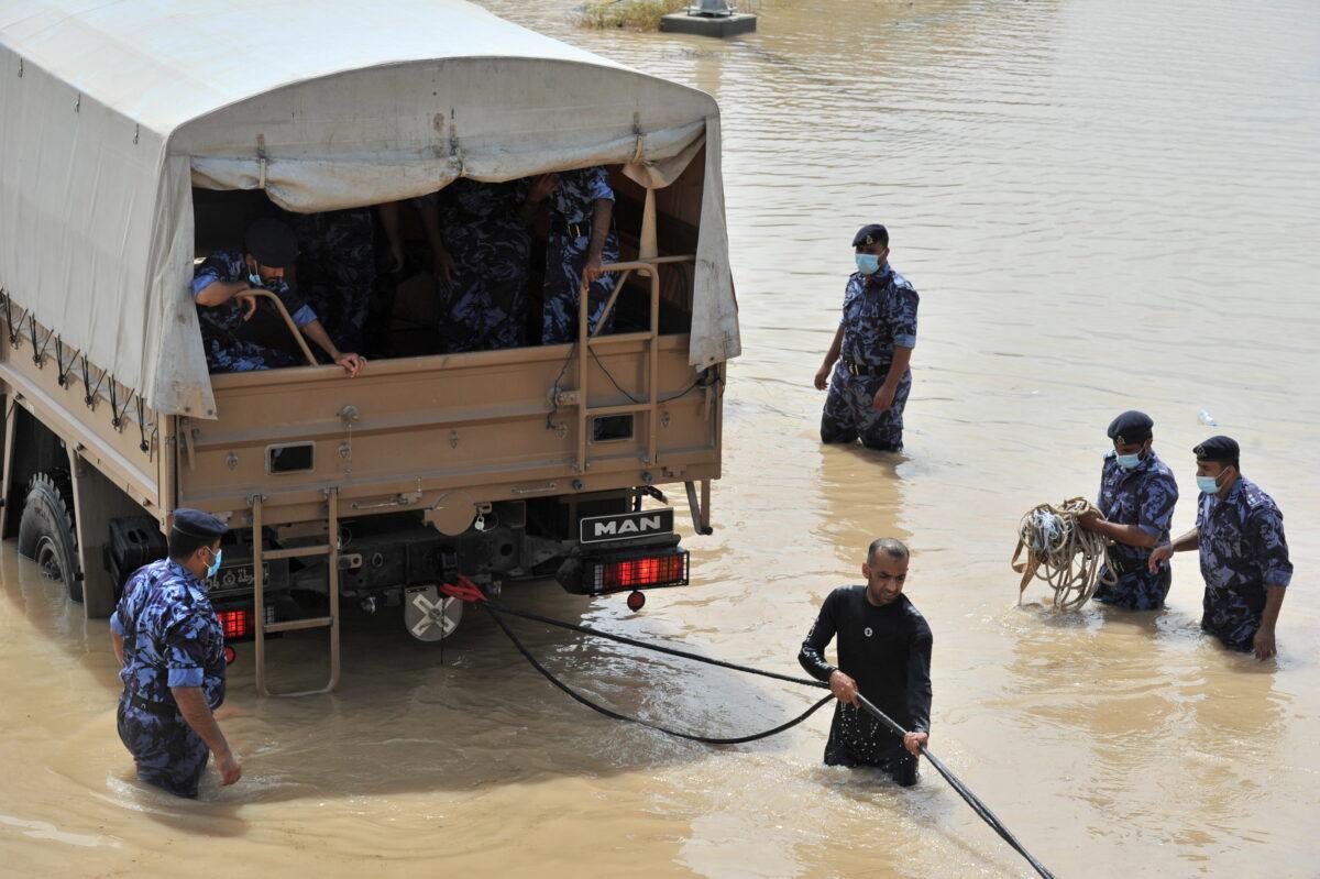 Oman Military officials repair damages caused by Cyclone Shaheen in Al Musanaa, Oman, on Oct. 4, 2021. (Oman News Agency/Handout via Reuters)