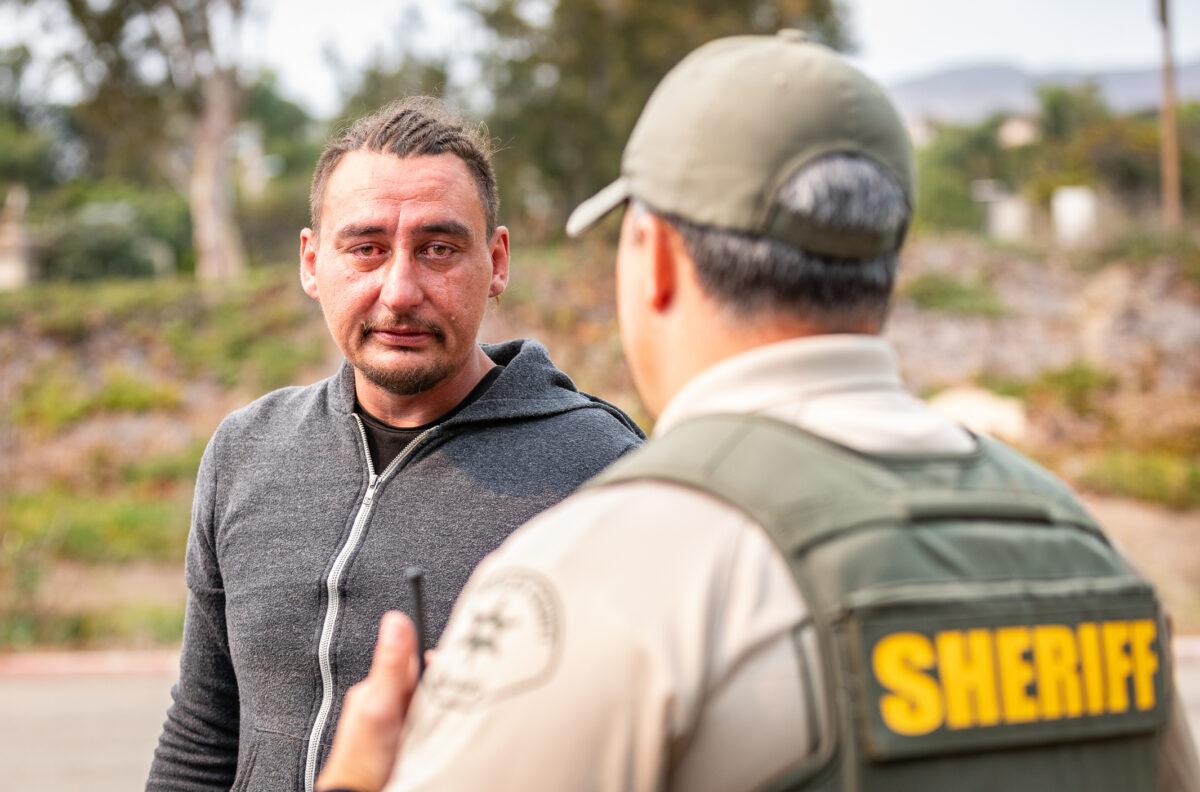 Jon, a homeless man, cries while speaking with members of the Los Angeles Sheriff's Department Homeless Outreach Services Team (HOST) in Malibu, Calif., on Sept. 23, 2021. (John Fredricks/The Epoch Times)
