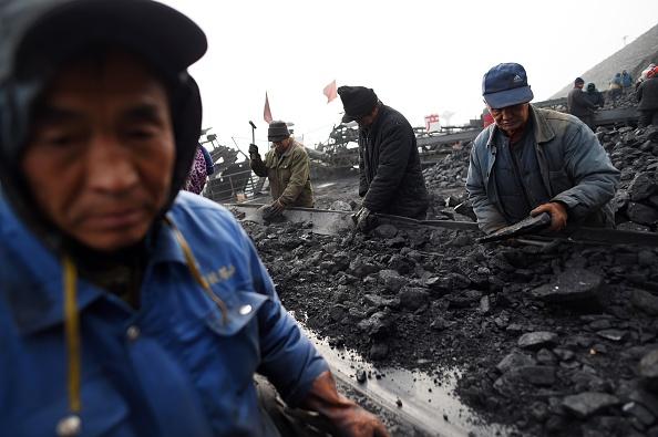 In this photo taken on Nov. 20, 2015, workers sort coal on a conveyer belt, near a coal mine at Datong, in China's northern Shanxi Province. (Greg Baker/AFP via Getty Images)