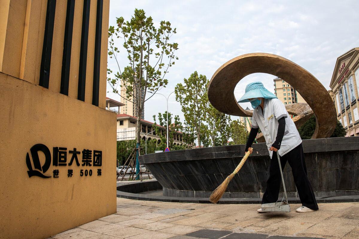 A cleaner wears a mask while sweeping the floor in Evergrande City in Wuhan, Hubei Province, China, on Sept. 24, 2021. (Getty Images)