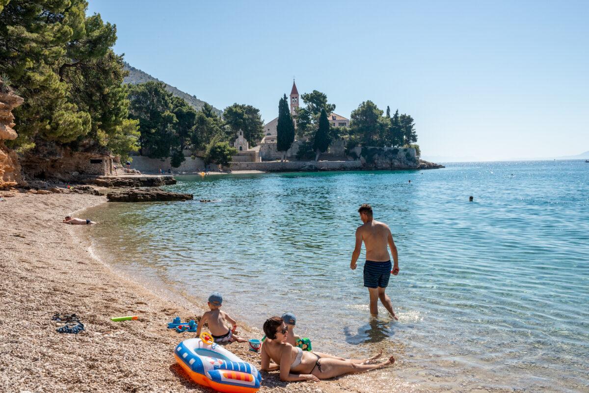 A family enjoys the beach close to the coastal trail to reach the Dominican Monastery in Bol, Croatia, on June 28, 2021. (Elisabetta Zavoli/Getty Images)