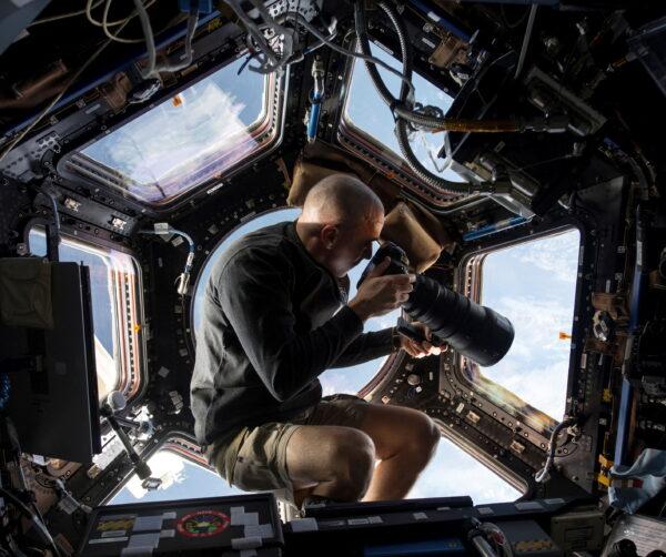 NASA astronaut Chris Cassidy, an Expedition 36 flight engineer, using a 400mm lens on a digital still camera to photograph a target of opportunity on Earth some 250 miles below him in this NASA image released on June 10, 2013. (NASA/Handout via Reuters)