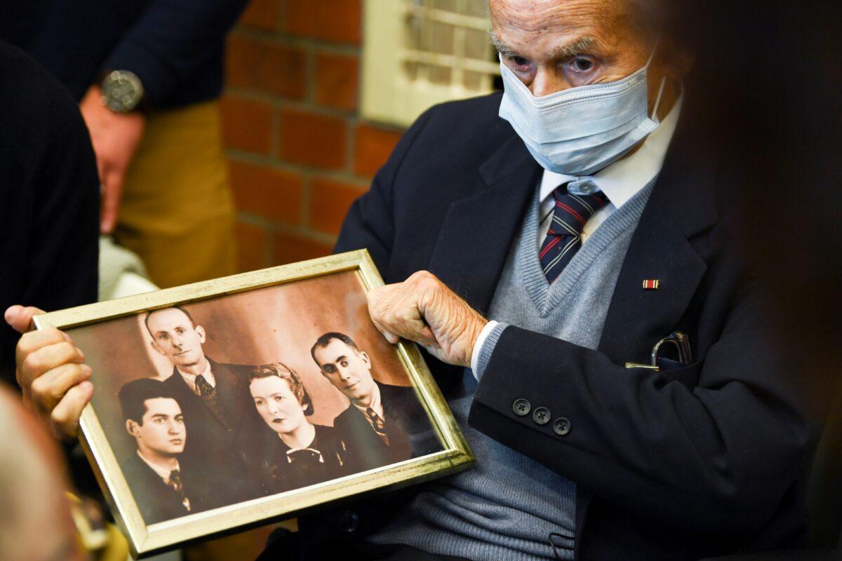Holocaust survivor Leon Schwarzbaum holds a picture in the courtroom during a trial against a 100-year-old former security guard of the Sachsenhausen concentration camp, at the Landgericht Neuruppin court in Brandenburg, Germany, on Oct. 7, 2021. (Annegret Hilse/Reuters)