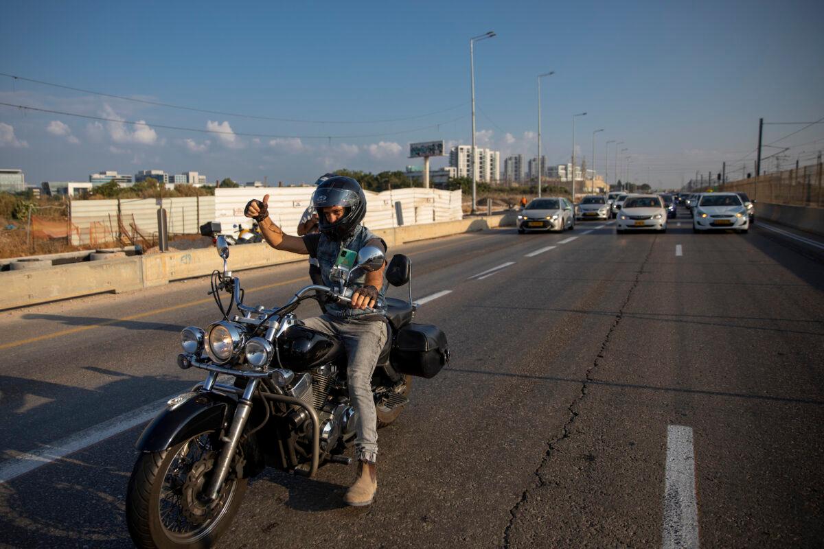  A convoy of cars slow traffic amid a demonstration against the Health Ministry's "green pass" restrictions, on Ayalon highway, in Tel Aviv, Israel, on Oct. 3, 2021. (Oded Balilty/AP Photo)