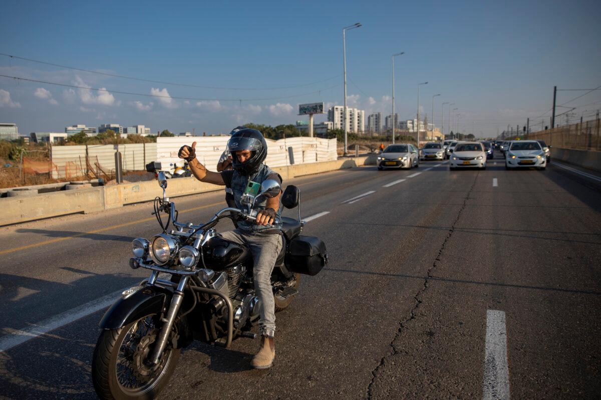 A convoy of cars slow traffic amid a demonstration against the Health Ministry's "green pass" restrictions, on Ayalon highway, in Tel Aviv, Israel, on Oct. 3, 2021. (Oded Balilty/AP Photo)