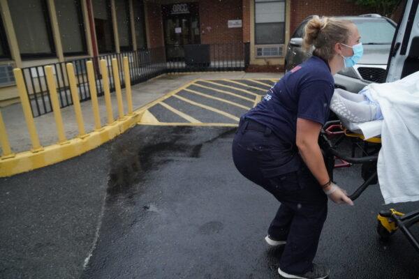 EMS worker Bailey Thornton loads an obese patient in Chattanooga, Tenn., on Oct. 4, 2021. (Jackson Elliott/The Epoch Times)