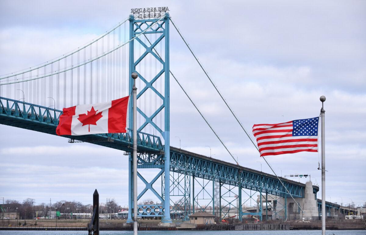 Canadian and American flags fly near the Ambassador Bridge at the Canada–U.S. border crossing in Windsor, Ont., in a file photo. (The Canadian Press/Rob Gurdebeke)