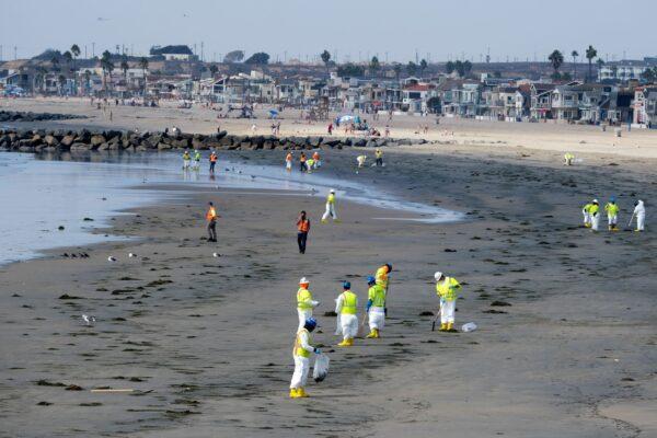 Workers in protective suits clean the contaminated beach after an oil spill in Newport Beach, Calif., on Oct. 6, 2021. (Ringo H.W. Chiu/AP Photo)