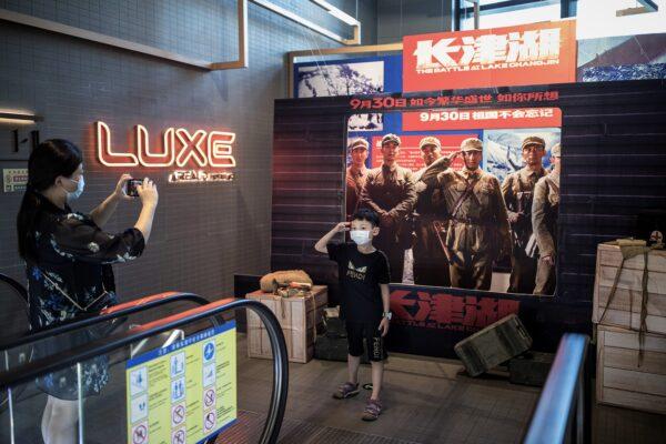 A boy poses in front of the movie poster of “The Battle at Lake Changjin" in a cinema in Wuhan, Hubei Province, China, on Oct. 2, 2021. (Getty Images)