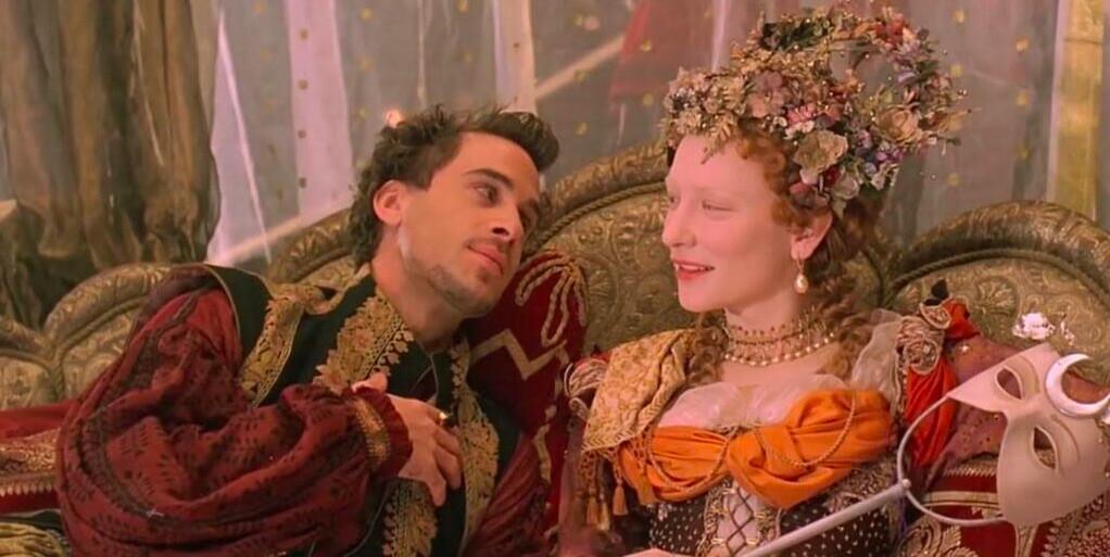 Robert Dudley, Earl of Leicester (Joseph Fiennes), and Elizabeth I, Queen of England (Cate Blanchett) dally on a couch at a costume party, in “Elizabeth.” (PolyGram Filmed Entertainment)