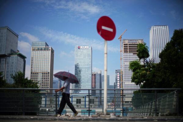 A man walks past a 'No Entry' traffic sign near the headquarters of China's Evergrande Group in Shenzhen, Guangdong Province, in China on Sept. 26, 2021. (Aly Song/Reuters)