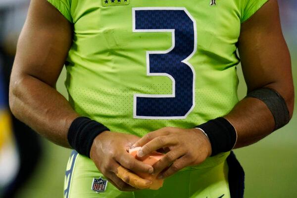 Seattle Seahawks quarterback Russell Wilson holds a sponge near his taped injured finger during the fourth quarter of an NFL football game against the Los Angeles Rams, in Seattle, Wash., on Oct. 7, 2021. (Elaine Thompson/AP Photo)