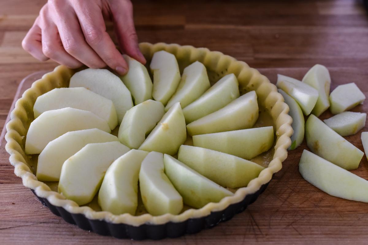 Arrange the apple wedges at the bottom of the crust in a circular pattern. (Audrey Le Goff)