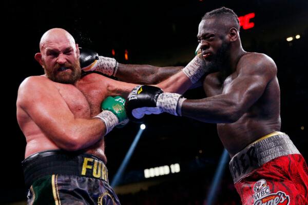 Deontay Wilder (R) and Tyson Fury, of England, trade blows in a heavyweight championship boxing match in Las Vegas, on Oct. 9, 2021. (Chase Stevens/AP Photo)