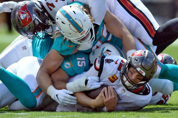 Miami Dolphins outside linebacker Andrew Van Ginkel (43) and outside linebacker Jaelan Phillips (15) team up to sack Tampa Bay Buccaneers quarterback Tom Brady (12) during the first half of an NFL football game in Tampa, Fla., on Oct. 10, 2021. (Jason Behnken/AP Photo)