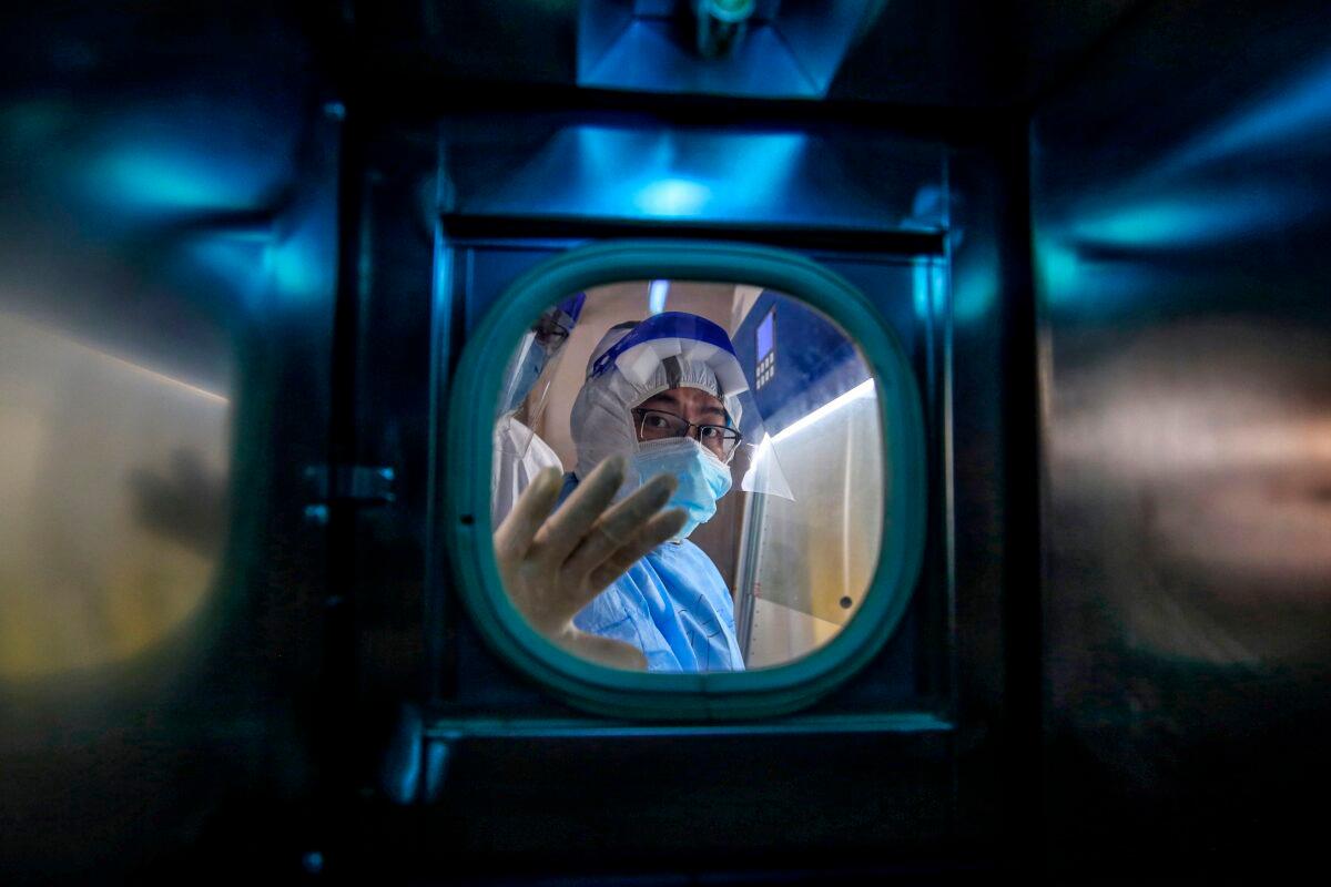  A medical staff member gestures inside an isolation ward at Red Cross Hospital in Wuhan in China’s Hubei Province on March 10, 2020. (STR/AFP via Getty Images)