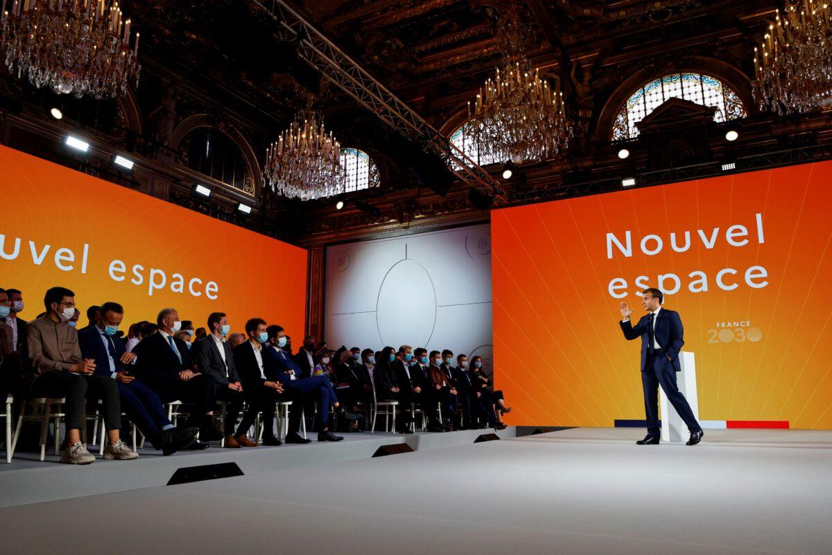 French President Emmanuel Macron gestures as he speaks in front of a screen with the words reading "New space" during the presentation of the "France 2030" investment plan at the Elysee Presidential Palace in Paris on Oct. 12, 2021. (Ludovic Marin/Pool via Reuters)