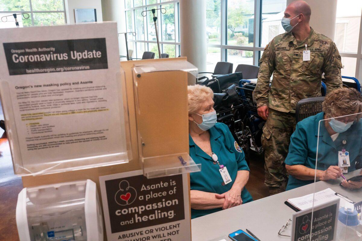 An Oregon National Guardsman works with hospital staff at an intake station at Three Rivers Asante Medical Center in Grants Pass, Ore., on Sept. 9, 2021. (Nathan Howard/Getty Images)