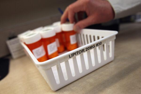 A person takes a bottle of cholesterol-reduction medication while filling prescriptions at a community health center in Aurora, Colorado on March 27, 2012. (John Moore/Getty Images)