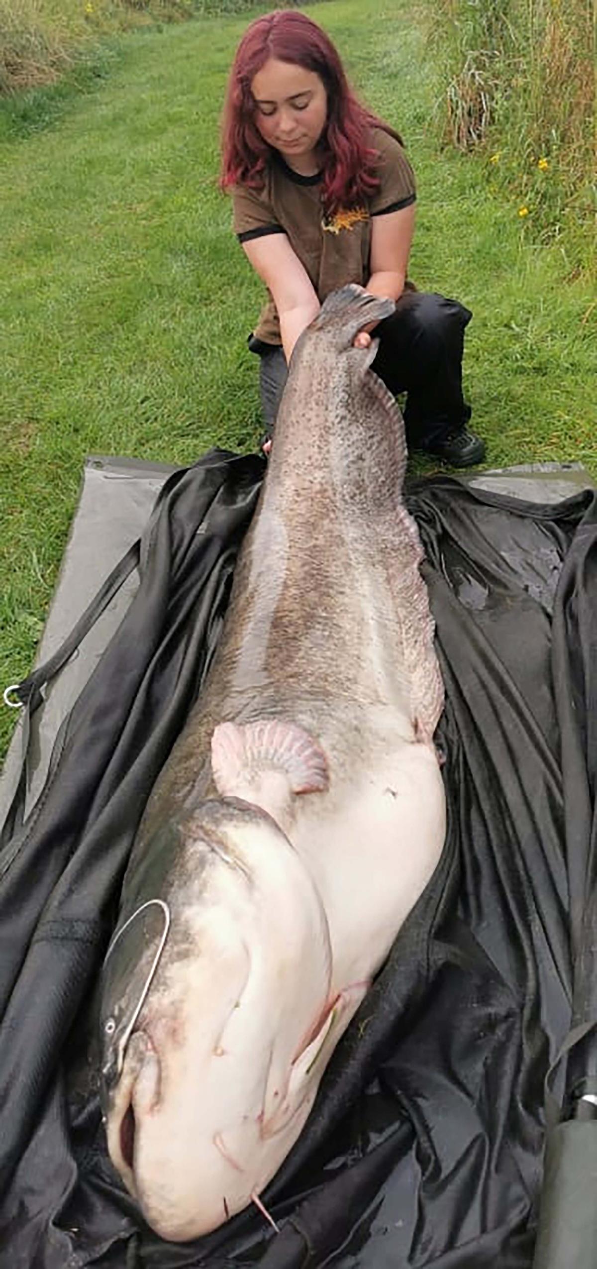 Hannah Truscott poses with her catfish catch. (SWNS)