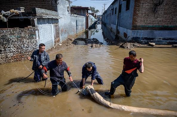 Rescuers drain flood waters after heavy rainfall at a flooded area in Jiexiu in the city of Jinzhong in China's northern Shanxi province on October 11, 2021. (AFP via Getty Images)