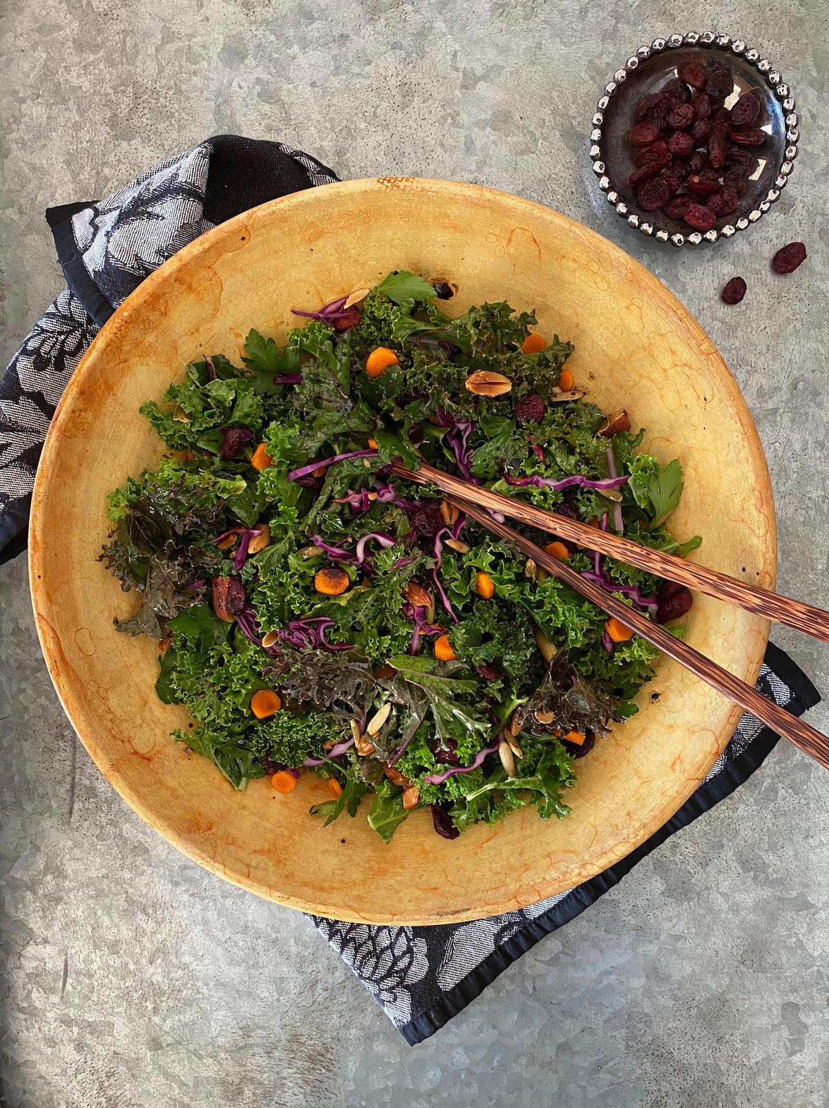 A mountain of kale leaves mingle with almonds, dried cranberries, and pumpkin seeds, bound together by a robust balsamic vinaigrette. (Lynda Balslev for Tastefood)
