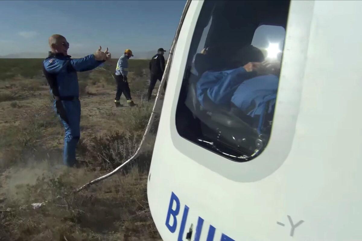 In this still image from video, billionaire Jeff Bezos gives a thumbs-up outside the capsule of Blue Origin's New Shepard mission NS-18, which carried "Star Trek" actor William Shatner and 3 other passengers on a suborbital flight, after it landed by parachute near Van Horn, Texas, on Oct. 13, 2021. (Blue Origin/Handout via Reuters)