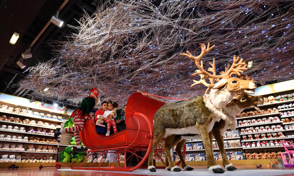 A Hamleys's elf and child actors sit in a sleigh drawn by reindeers displayed inside the shop during the annual Hamleys Christmas toy photocall at their toyshop in central London on Oct. 15, 2020. (Justin Tallis/AFP via Getty Images)