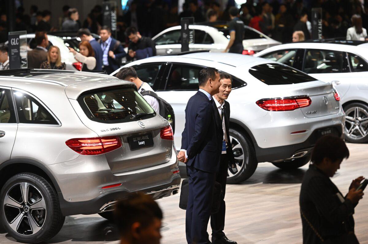 People look at cars on the Mercedes-Benz stand on the opening day of the Shanghai Auto Show on April 16, 2019. (Greg Baker/AFP via Getty Images)