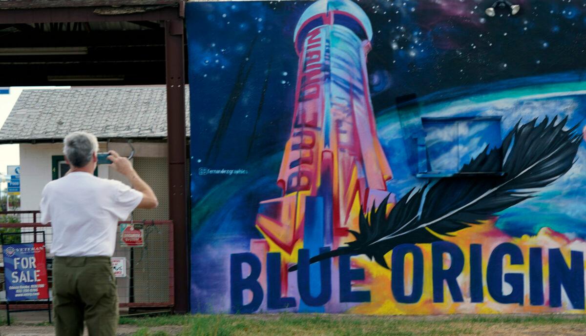 Gene Walker, of Denison, Texas, makes a photo of a Blue Origin mural in Van Horn, Texas, on Oct. 12, 2021. (LM Otero/AP Photo)