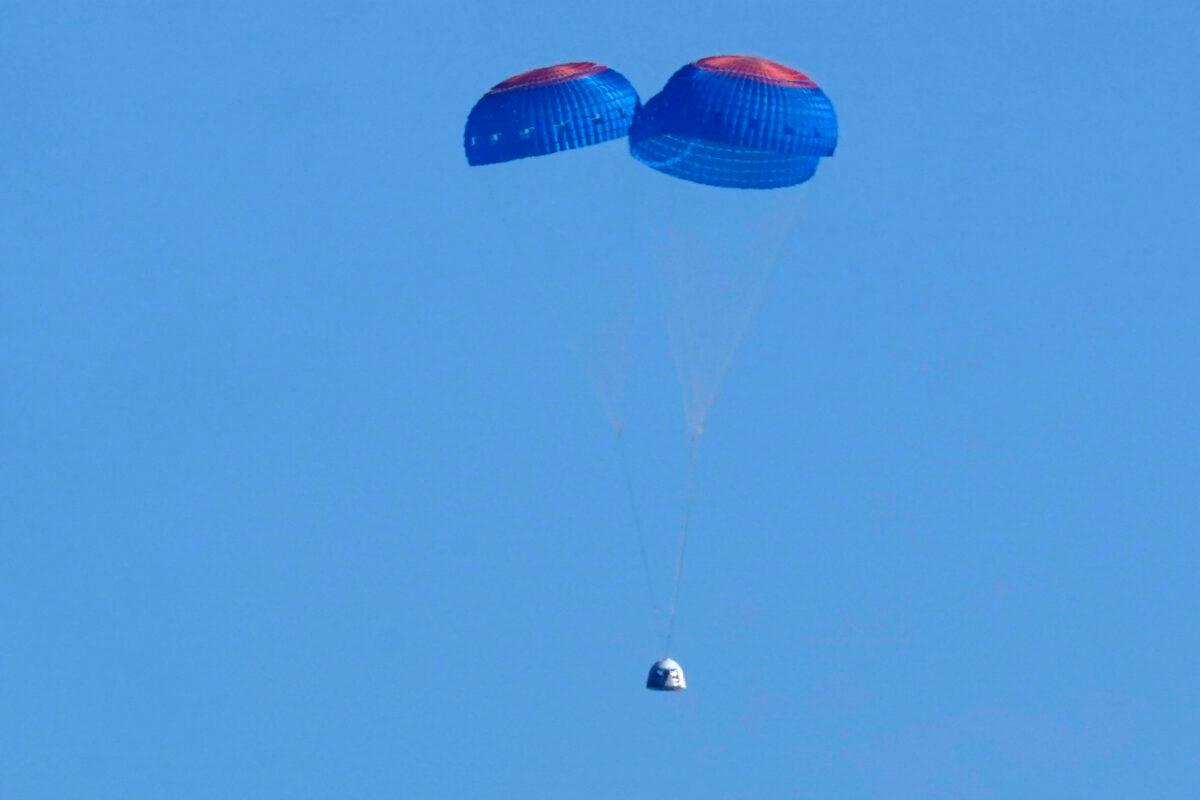 Parachutes slow the descent of the Blue Origin capsule with passengers William Shatner, Chris Boshuizen, Audrey Powers, and Glen de Vries near the company's spaceport near Van Horn, Texas, on Oct. 13, 2021. (LM Otero/AP Photo)