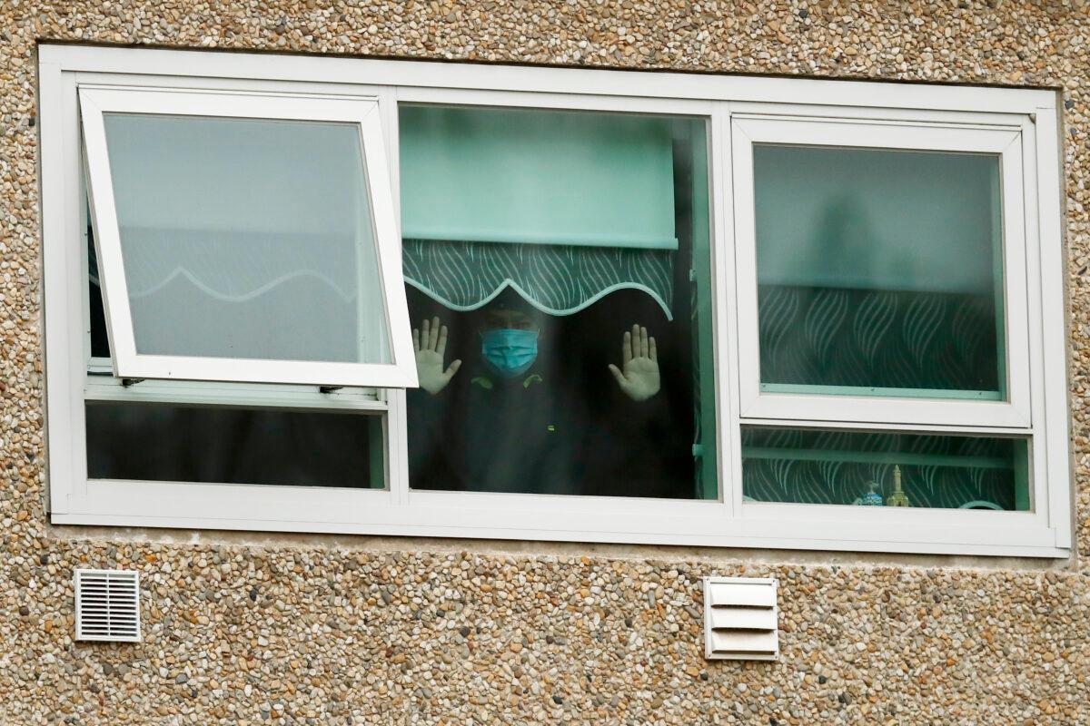 A man looks out a window at the Flemington Towers public housing complex in Melbourne, Australia, on July 6, 2020. (Darrian Traynor/Getty Images)