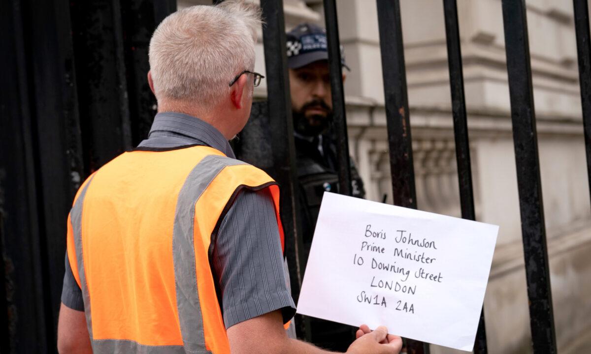 A member of Insulate Britain attempts to hand in a letter for Prime Minister Boris Johnson at 10 Downing Street, London, on Oct. 14, 2021. (Aaron Chown/PA)