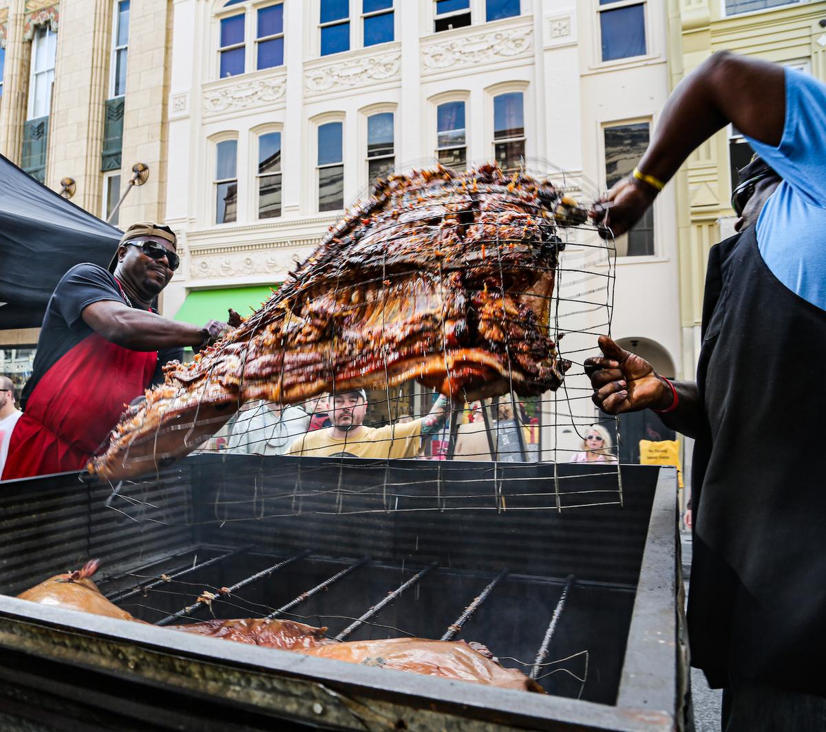 THE FINAL HOUR: Flipping the hog, one of the last steps in cooking it, requires coordination and trust. (Angie Mosier)