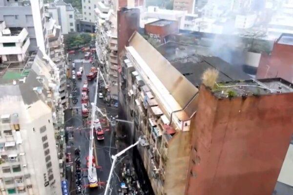 In this image taken from video by Taiwan's EBC, firefighters shoot water into a building that caught fire in Kaohsiung, in southern Taiwan on Oct. 14, 2021. (EBC via AP)