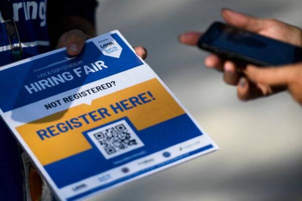A person scans a QR code with their phone to register as they wait in line to attend a job fair for employment with SoFi Stadium and Los Angeles International Airport employers, at SoFi Stadium on Sept. 9, 2021, in Inglewood, California. (Patrick T. Fallon/AFP via Getty Images)