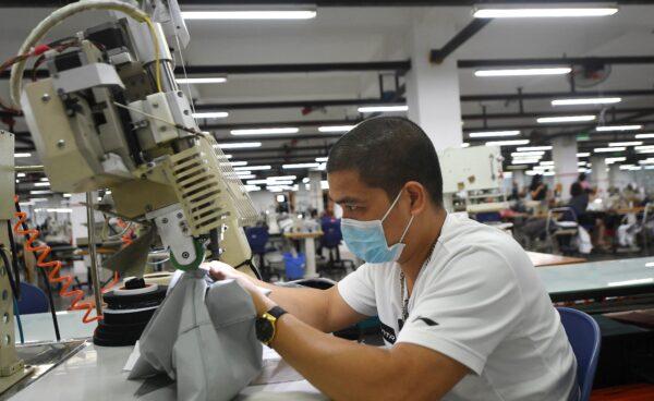 A worker wearing a face mask while working at the Maxport factory, which makes activewear for various textile clothing brands, in Hanoi, Vietnam, on Sept. 21, 2021. (Nhac Nguyen/AFP via Getty Images)