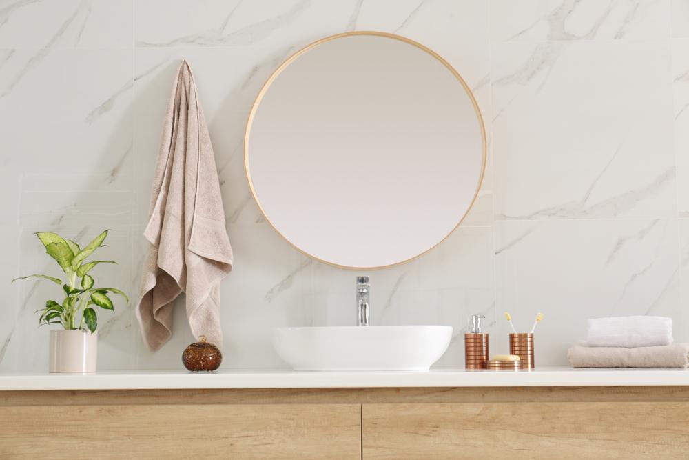 Try a bathroom mirror with a different shape or an interesting trim detail. (New Africa/Shutterstock)