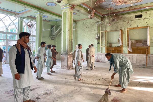 After a suicide bomb attack, Afghan men inspect the damage inside a Shiite mosque in Kandahar, Afghanistan, on Oct. 15, 2021. (Javed Tanveer/AFP via Getty Images)