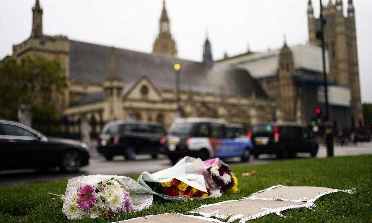 Flowers left in Parliament Square following the death of Conservative MP Sir David Amess, in London on Oct. 16, 2021. (Aaron Chown/PA)