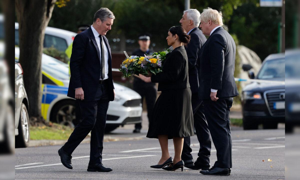 Britain's Prime Minister Boris Johnson (R), Britain's main opposition Labour Party leader Keir Starmer (L), Speaker of the House Lindsay Hoyle (2R), and Britain's Home Secretary Priti Patel (2L) lay floral tributes as at the scene of the fatal stabbing of Conservative British lawmaker David Amess, at Belfairs Methodist Church in Leigh-on-Sea, a district of Southend-on-Sea, in southeast England on Oct. 16, 2021. (Tolga Akmen/AFP via Getty Images)