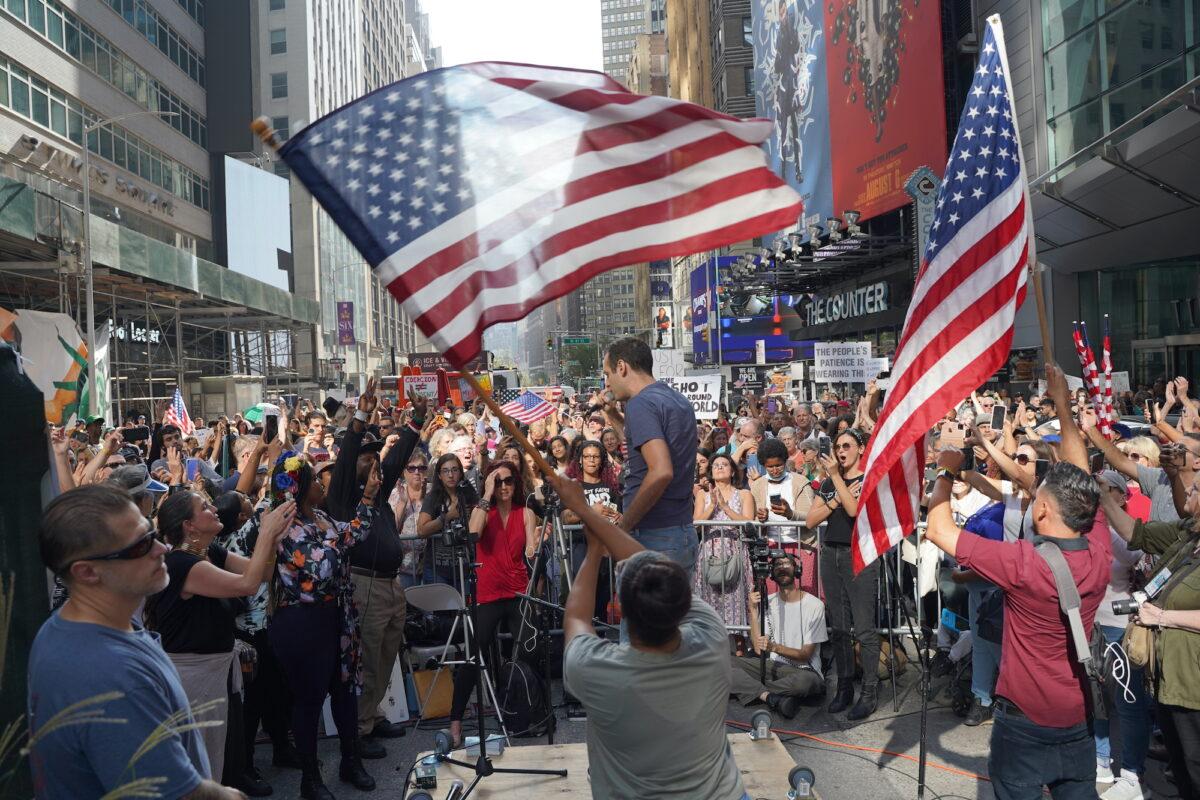 The crowd listens to the National Anthem at the Broadway Rally For Freedom in Manhattan, New York, on Oct. 16, 2021. (Enrico Trigoso/The Epoch Times)
